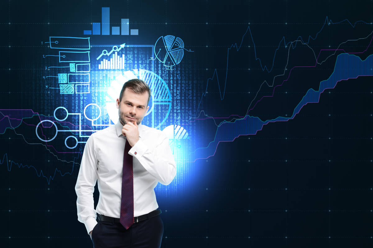 Business person with thoughtful expression standing against a dark background with brightly glowing charts and graphs