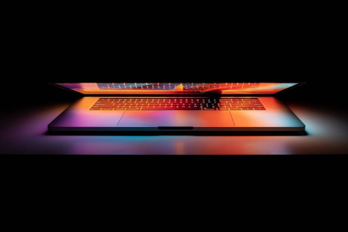 Colorful lights coming from a laptop screen against a black background